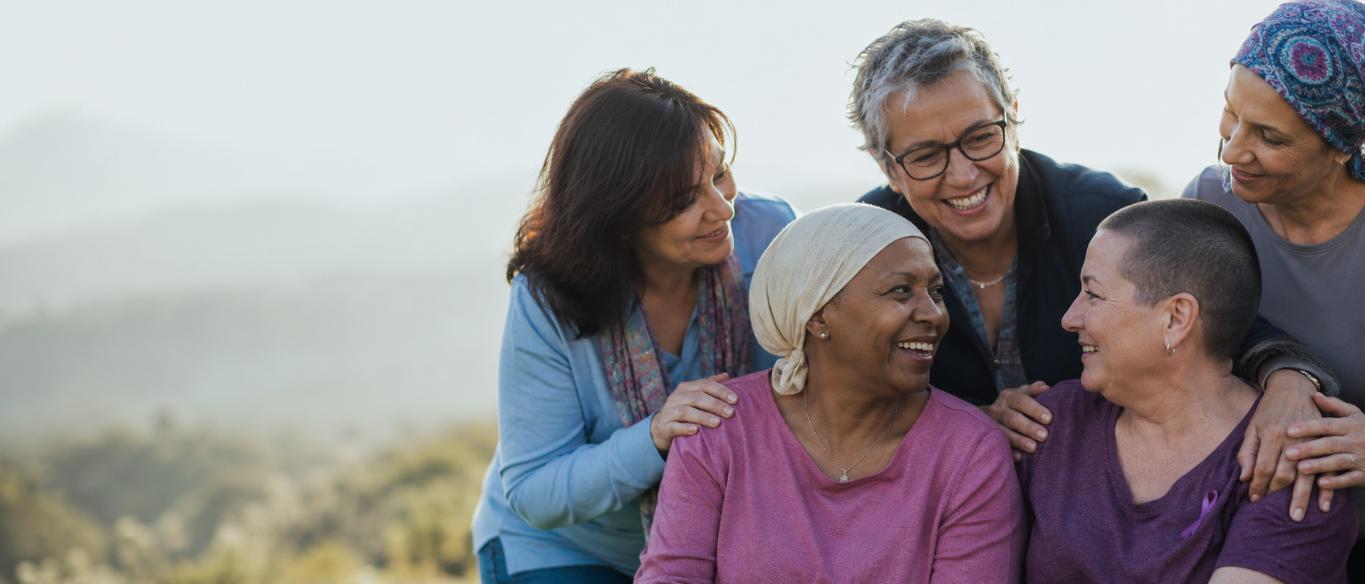 A diverse group of patients and survivors smiling together outdoors